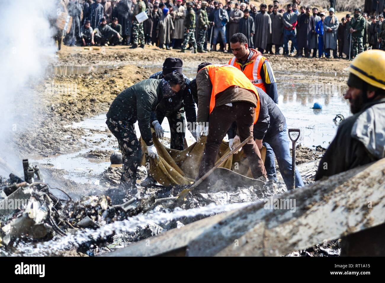 Rettungskräfte tragen die Leiche des Piloten nach einem indischen Militärflugzeuge in Budgam, 20 km von Srinagar, Kashmir abgestürzt. Eine indische Luftwaffe stürzte am Mittwoch in Budgam Bezirk von Kaschmir, die Tötung von sieben Personen, darunter sechs indische Luftwaffe Personal und ein Zivilist. Das Flugzeug aus technischen Gründen abgestürzt, sagten Beamte. Stockfoto