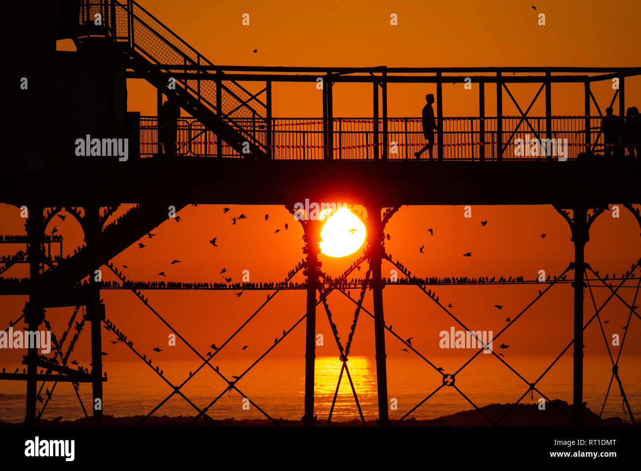 Aberystwyth Wales UK Mittwoch, den 27. Februar 2019. UK Wetter: Menschen am Meer Aberystwyth, wie die Sonne, die die meisten der sensationell heiß und sonnig, 'Winter' Wetter, während es dauert. Das Wetter Prognose zu starten ab morgen zu verschlechtern, mit mehr typische windig und kühler Anfang März Foto Keith Morris/Alamy Live Nachrichten erwartet Stockfoto