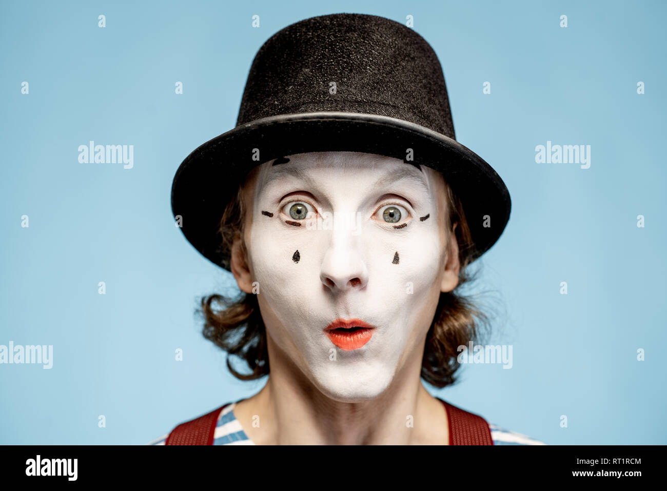 Nahaufnahme Porträt eines Schauspielers als Pantomime mit weißem Gesicht Make-up zeigt ausdrucksstarke Emotionen auf den blauen Hintergrund Stockfoto