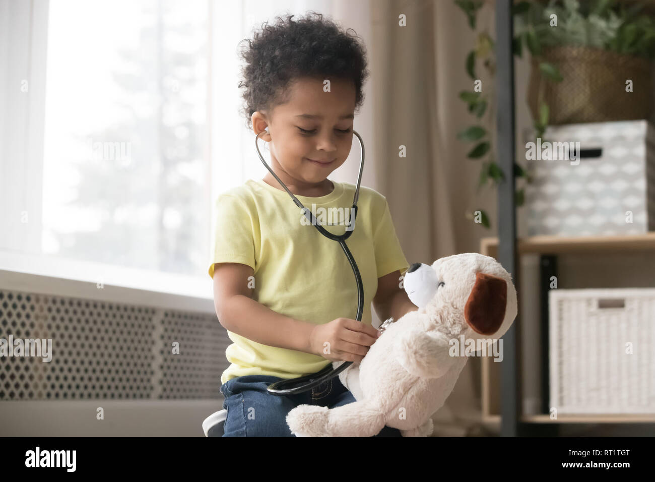 Cute afrikanischen Jungen spielen mit Spielzeug wie Arzt holding Stethoskop Stockfoto