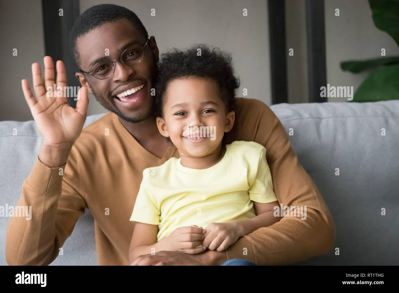 Happy afrikanischen Vater und Kind Sohn winkende Hände Aufnahme vlog Stockfoto