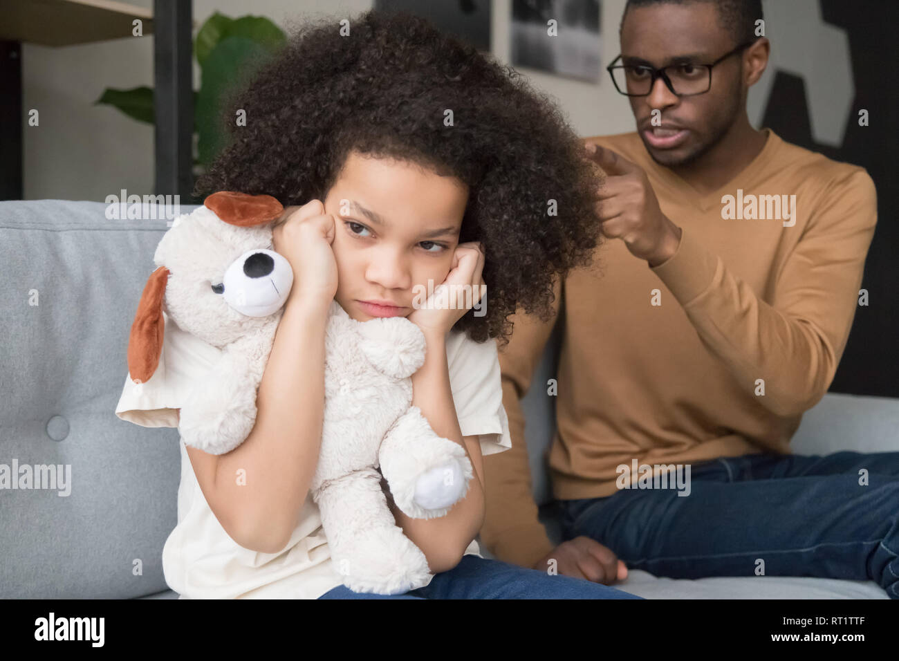 Hartnäckige afrikanisches Kind Mädchen schließen Ohren ignorieren wütend schwarz Dad Stockfoto