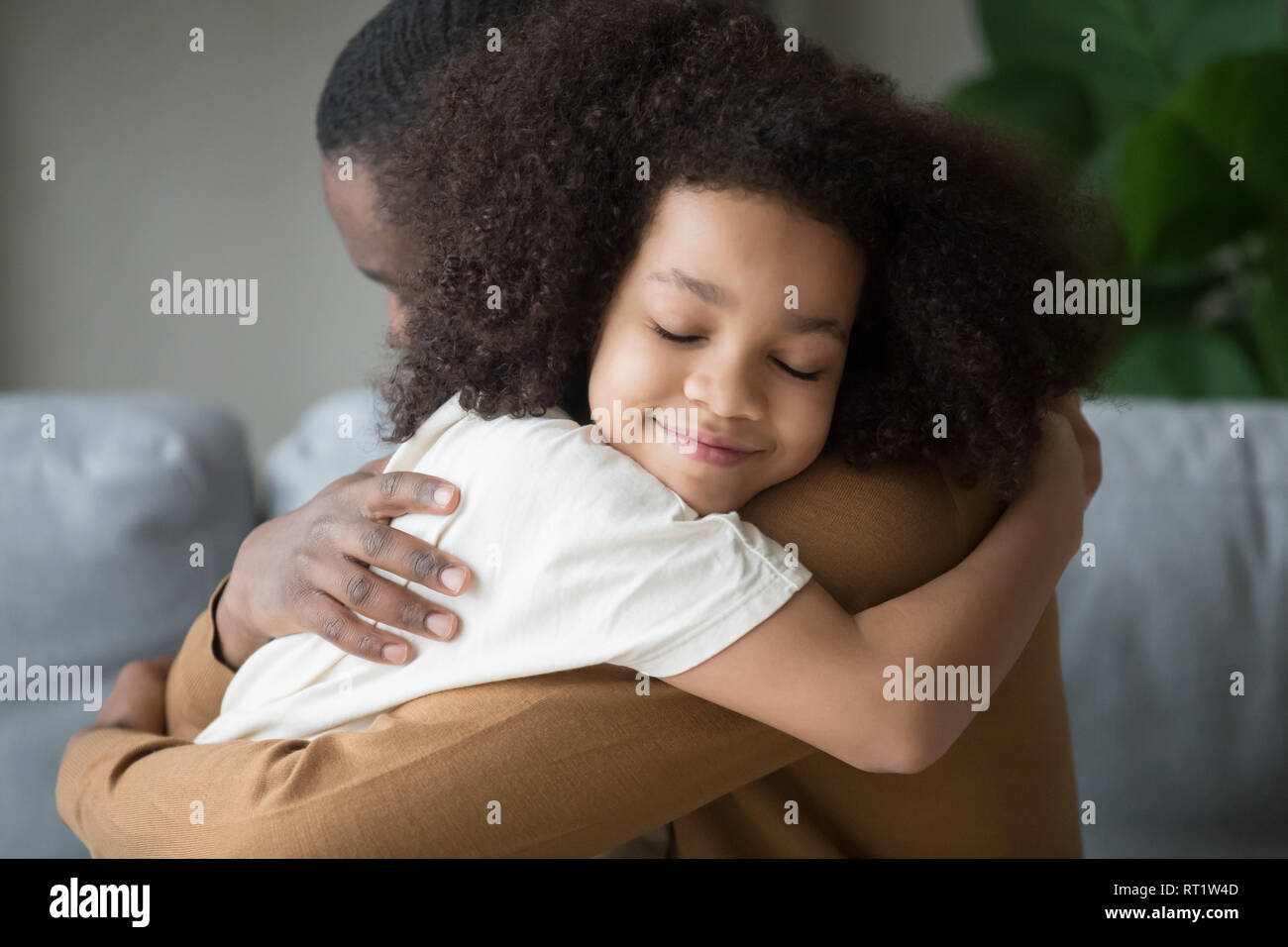 Süße Mischlinge Kind Tochter umarmt Vater Gefühl der Liebe Verbindung Stockfoto