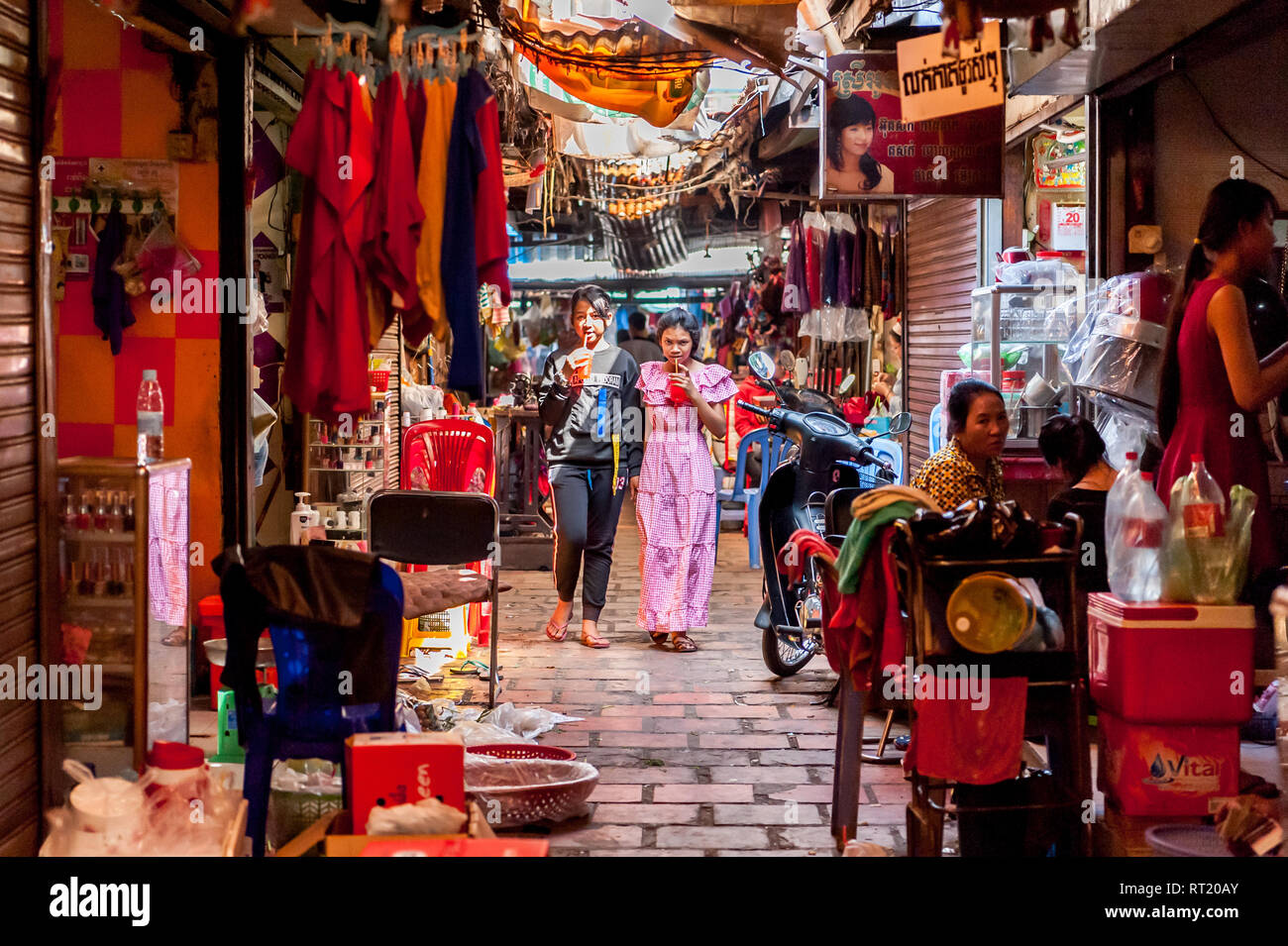 Szenen aus einem Innen- Markt in Phnom Penh, Kambodscha, Süd Ost Asien. Zwei junge kambodschanische Mädchen durch die geschäftige Markthalle in Phnom Penh wandern. Stockfoto