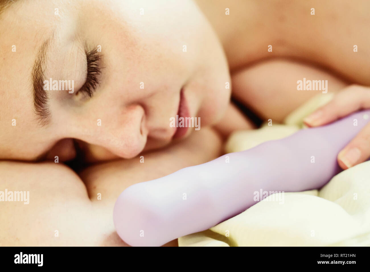 Schlafende junge Frau liegend auf Bett mit Vibrator, close-up  Stockfotografie - Alamy