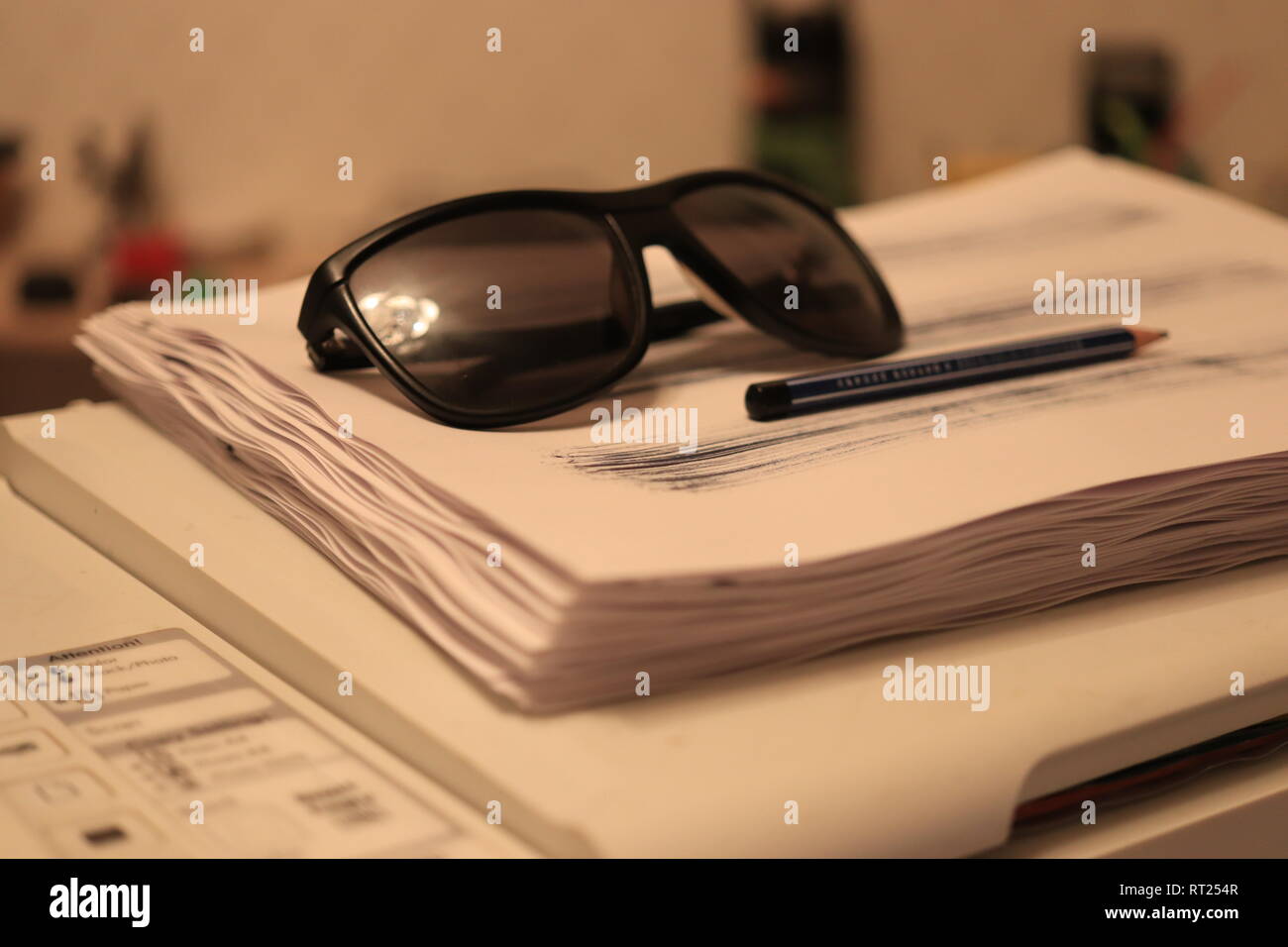Sonnenbrille mit Pen liegen auf einem Stapel Papier auf dem Drucker Stockfoto