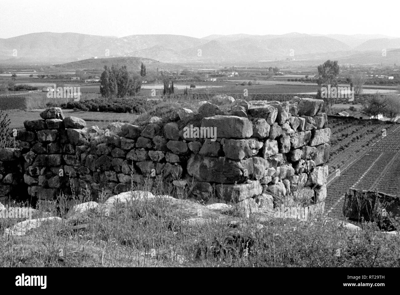 Spanien, Griechenland - die Reste einer alten Steinhütte vor dem Panorama von Gebirge, Landschaft und Feldern. Überreste einer alten Hütte. Stockfoto