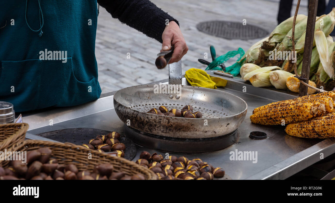 Street Food. Rösten und Verkauf von Süßen Hühneraugen und Kastanien an der Straße Ermou Athen, Griechenland. Stockfoto