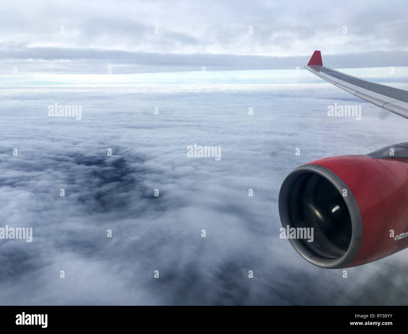 Ein Luftbild vom Flugzeug fliegen hoch über dem Boden. Ein Blick aus dem Fenster mit Motor und Flügel sichtbar in der Ebene. Stockfoto