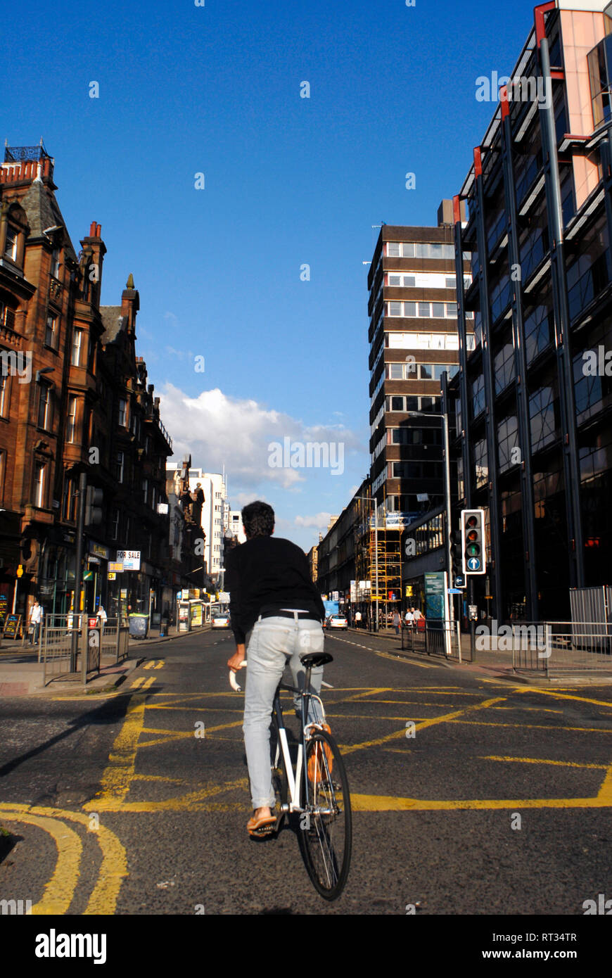 Ein Mann, der auf seinem Fahrrad an der Sauchiehall Street in Glasgow, Schottland, Großbritannien, unterwegs ist Stockfoto