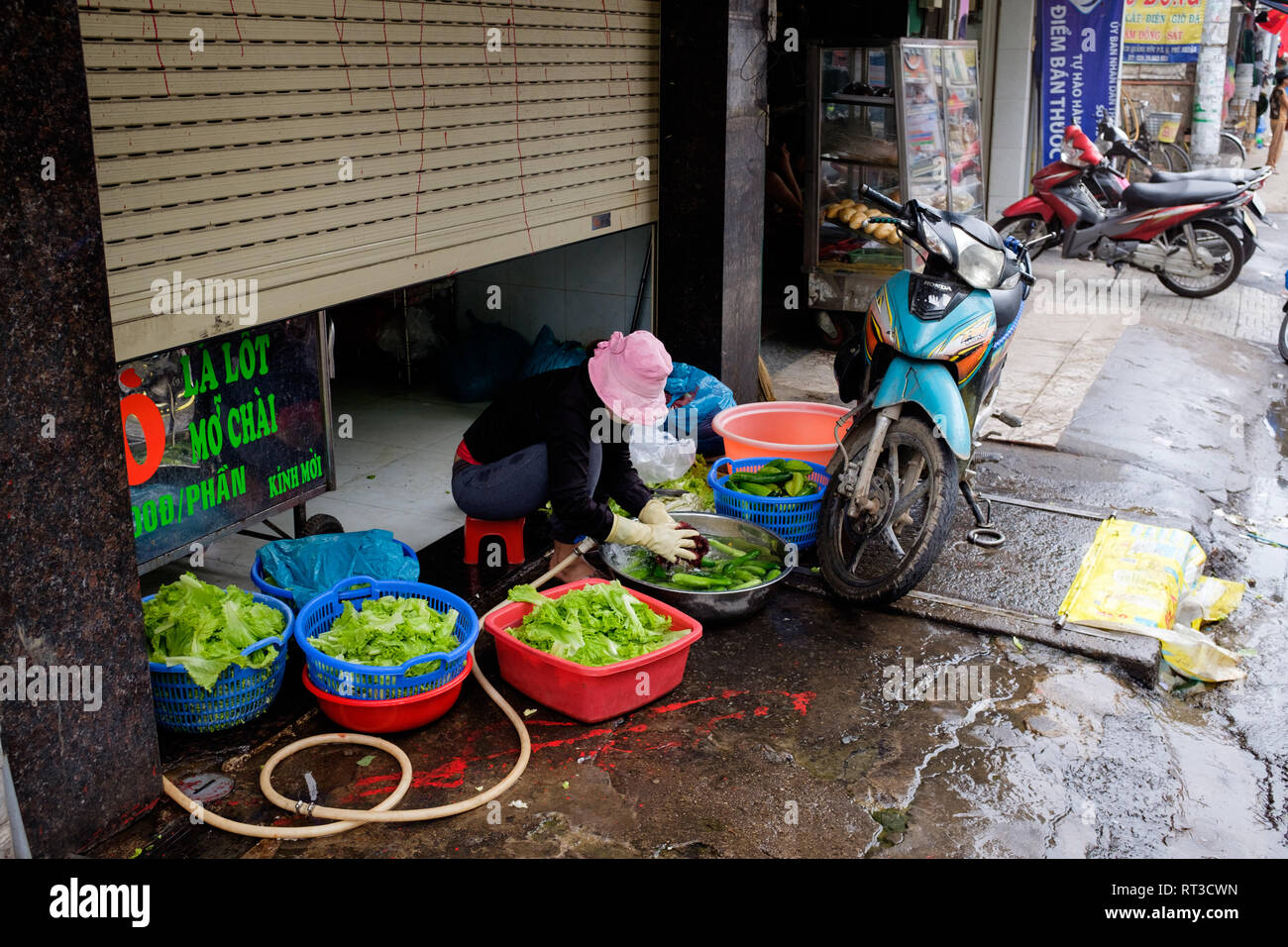 Eine Dame wäscht grünes Gemüse am Straßenrand, Ho Chi Minh City, Vietnam Stockfoto