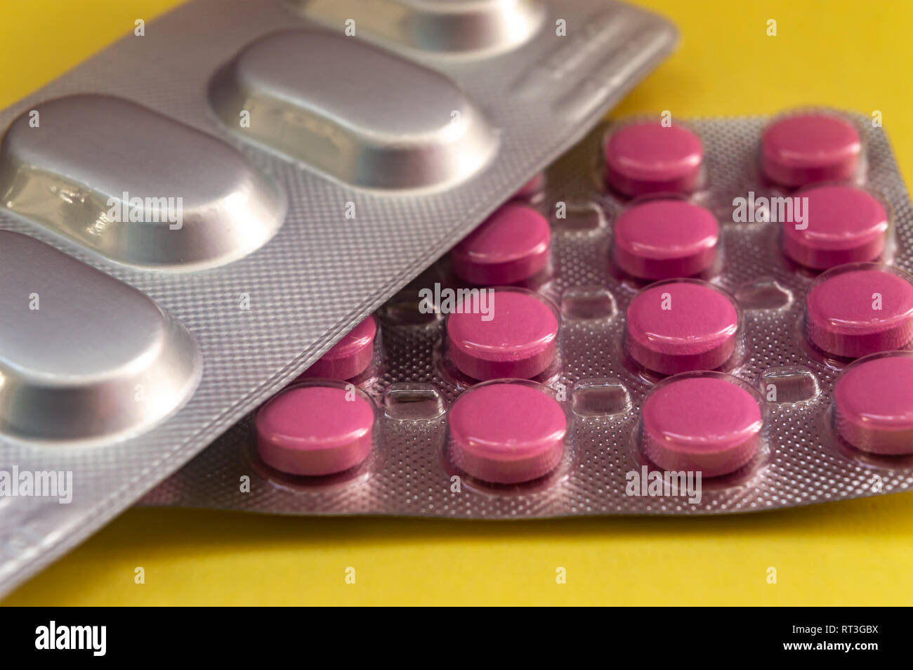 Rote runde Tabletten, ovale Tabletten auf gelbem Hintergrund  Stockfotografie - Alamy