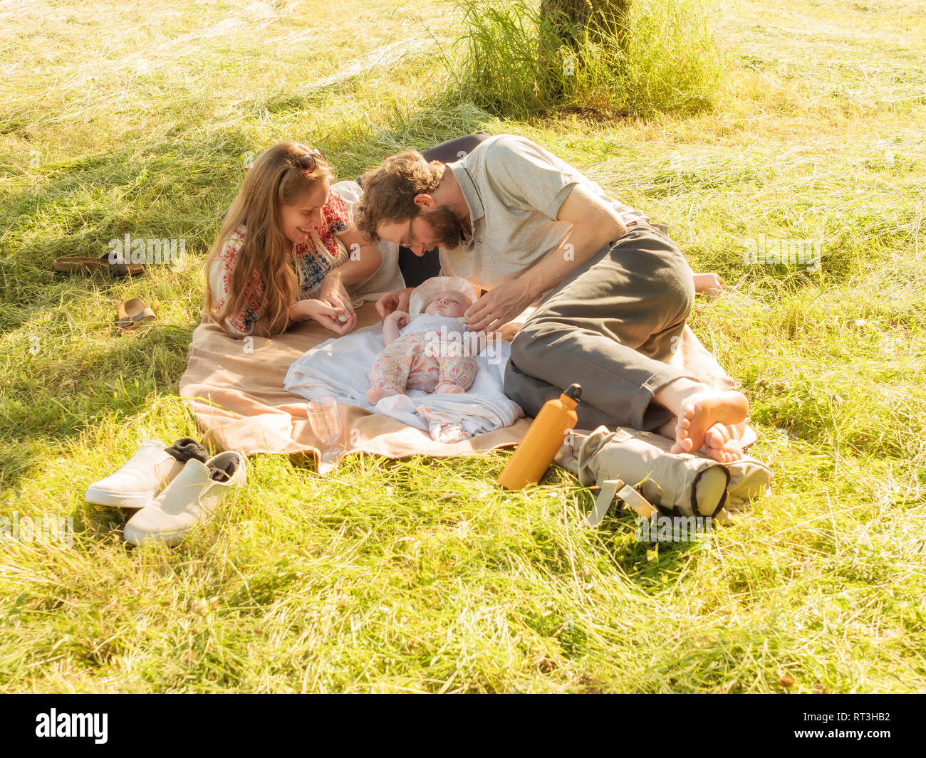 Junges Paar mit Baby Mädchen auf Decken auf einer Wiese Stockfoto