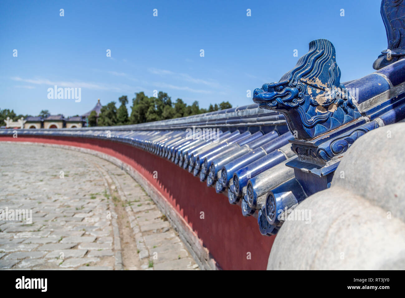 Ein blau glasiert Drachen Kopf schmückt eine rote kreisförmige Mauer überstiegen mit blauen Fliesen Glasur. Dies ist einer der Mauern des kreisförmigen Damm Altar. Stockfoto