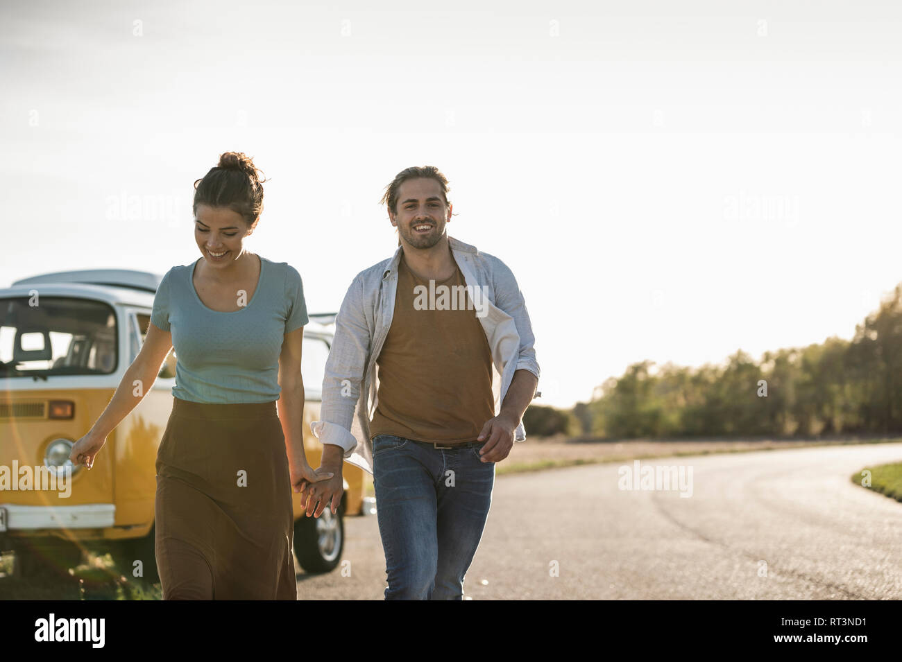 Glückliches Paar tun eine Reise mit einem Wohnmobil, Hand in Hand auf der Straße Stockfoto