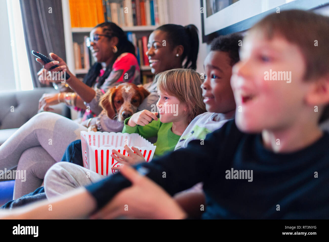 Multi-ethnischen Familie aufzupassen Film und Essen Popcorn Stockfoto
