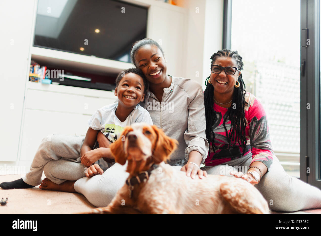 Portrait happy multi-Generation, Familie mit Hund auf Wohnzimmer Erdgeschoss Stockfoto