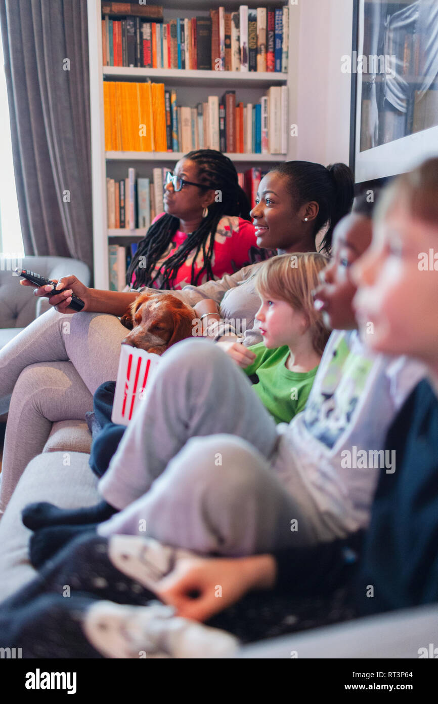 Familie aufzupassen Film und Essen Popcorn auf Sofa im Wohnzimmer Stockfoto