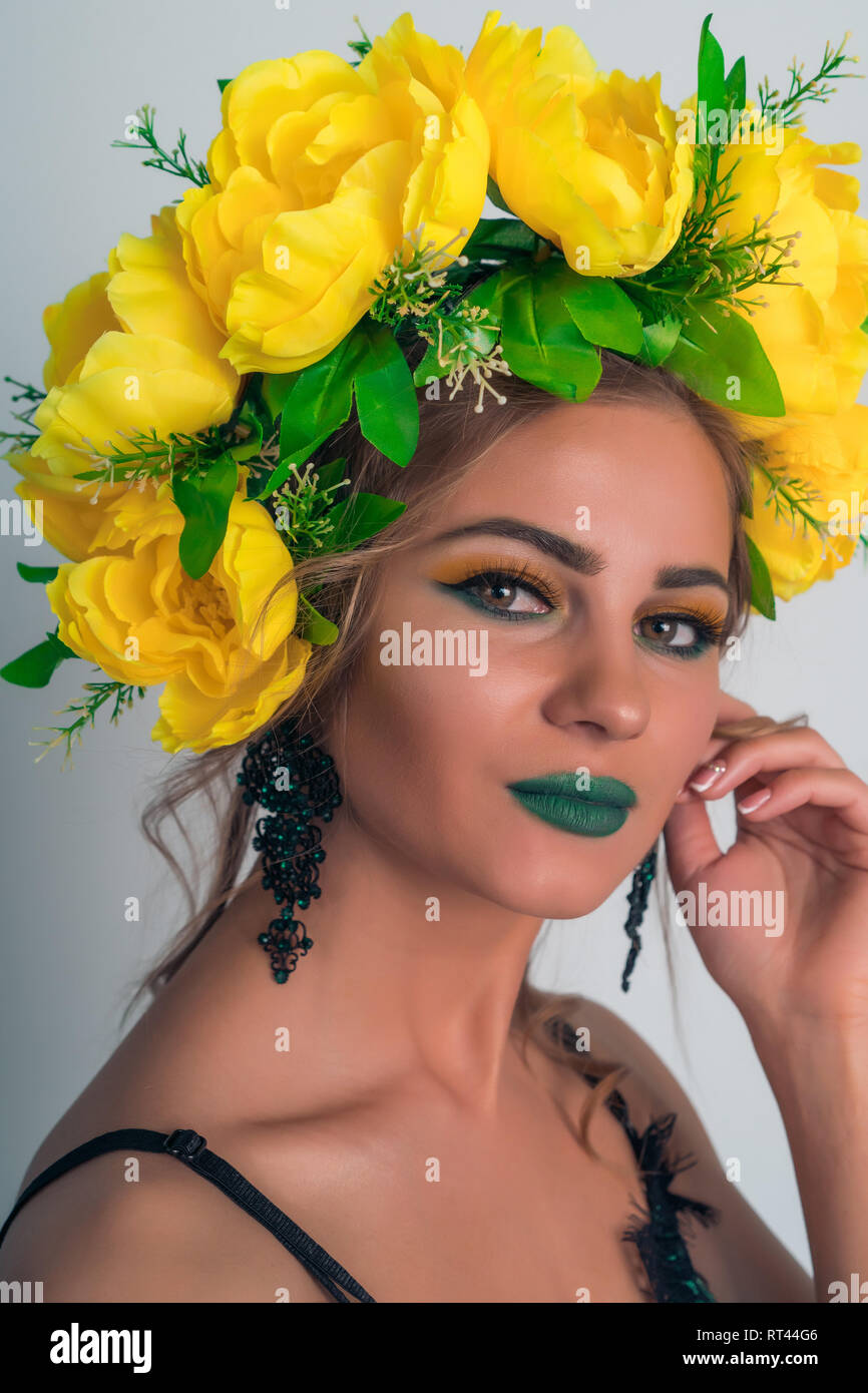 Porträt einer schönen Blondine mit hellen, Make-up und eine Felge von gelben Blumen Stockfoto