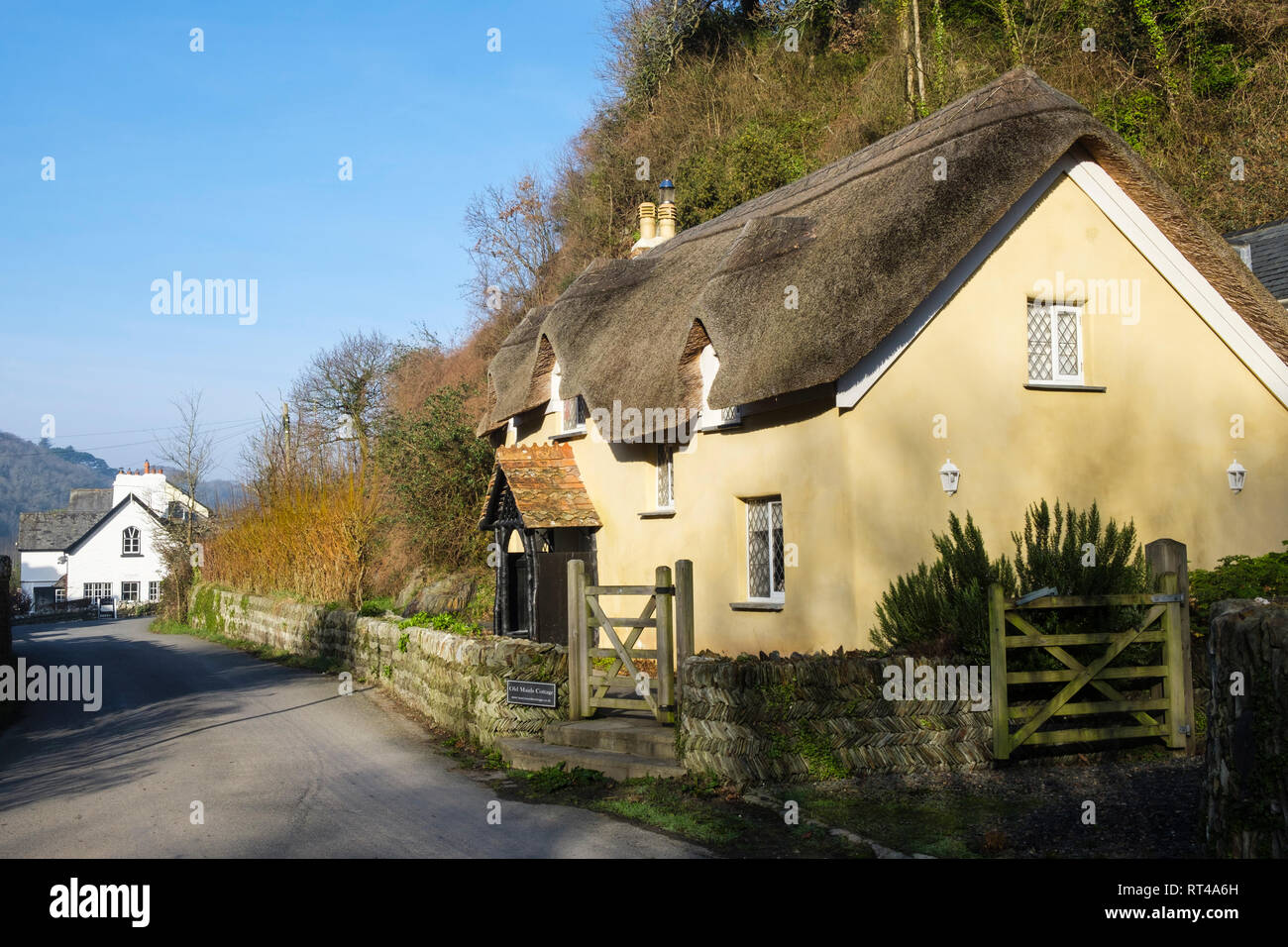 17. jahrhundert alten Zimmermädchen Cottage mit einem traditionellen Reetdach und Blick hinunter Lane, um alte Post in im hübschen Dorf Lee North Devon England Großbritannien Stockfoto