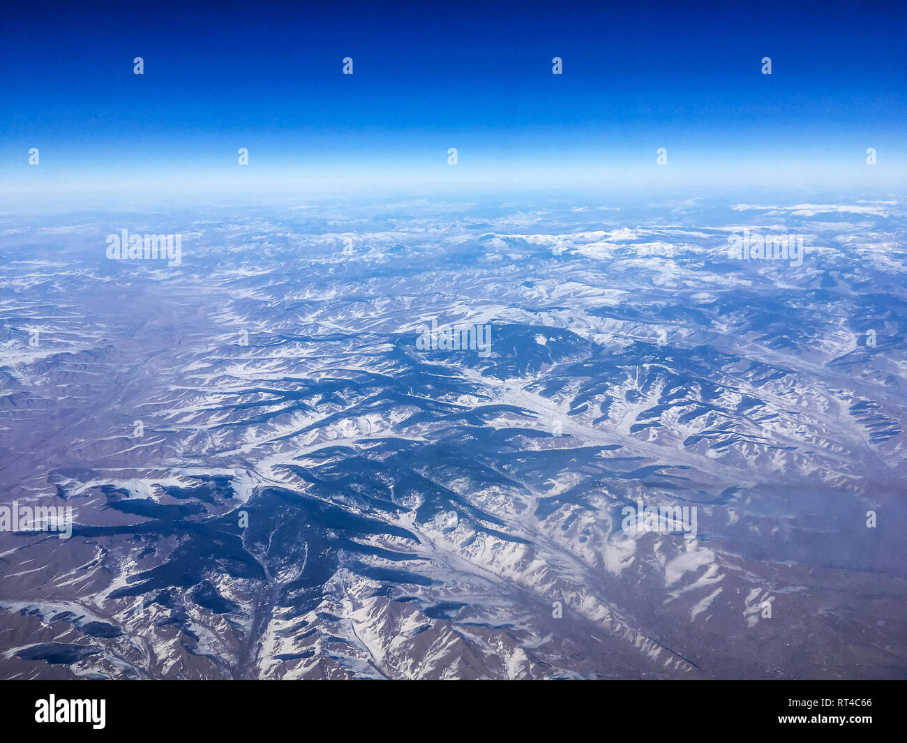 Ein Luftbild der Chinesischen Berge aus dem Flugzeug fliegen hoch über dem Boden. Ein Blick aus dem Fenster des Flugzeugs. Stockfoto
