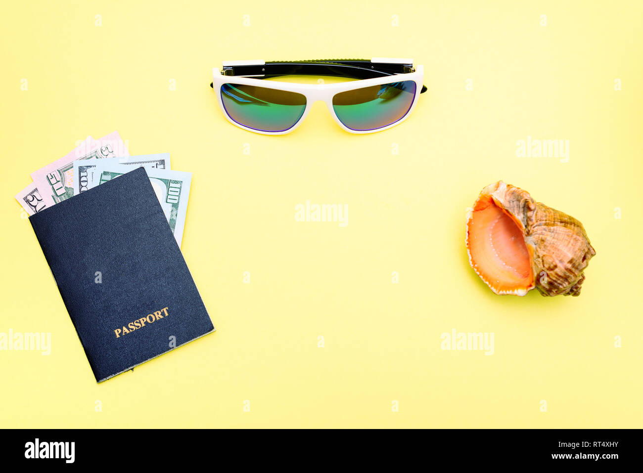 Konzept Urlaub. auf gelbem Hintergrund ist ein Pass, Geld, Sonnenbrille, Seashell Stockfoto