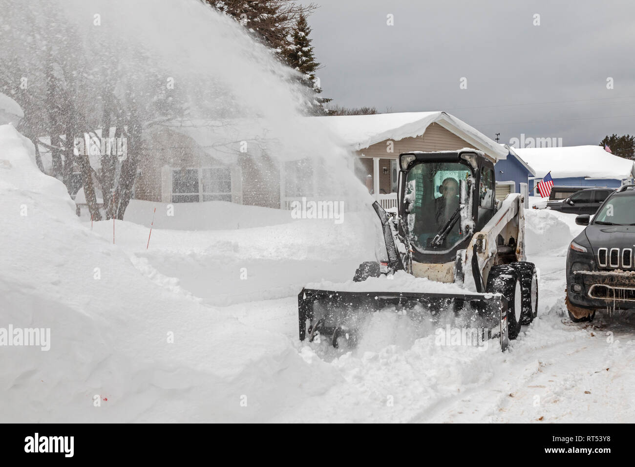 Grand Marais, Michigan - Eine industrielle Schneefräse löscht Schnee von einer Straße in einer Stadt am Lake Superior in der oberen Halbinsel von Michigan. Die Stadt averag Stockfoto