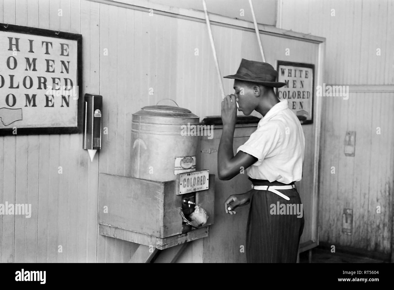 Eine afrikanische amerikanische Mann trinken aus einem Wasser Station mit der Bezeichnung in einer Straßenbahn-terminal Farbige Stockfoto