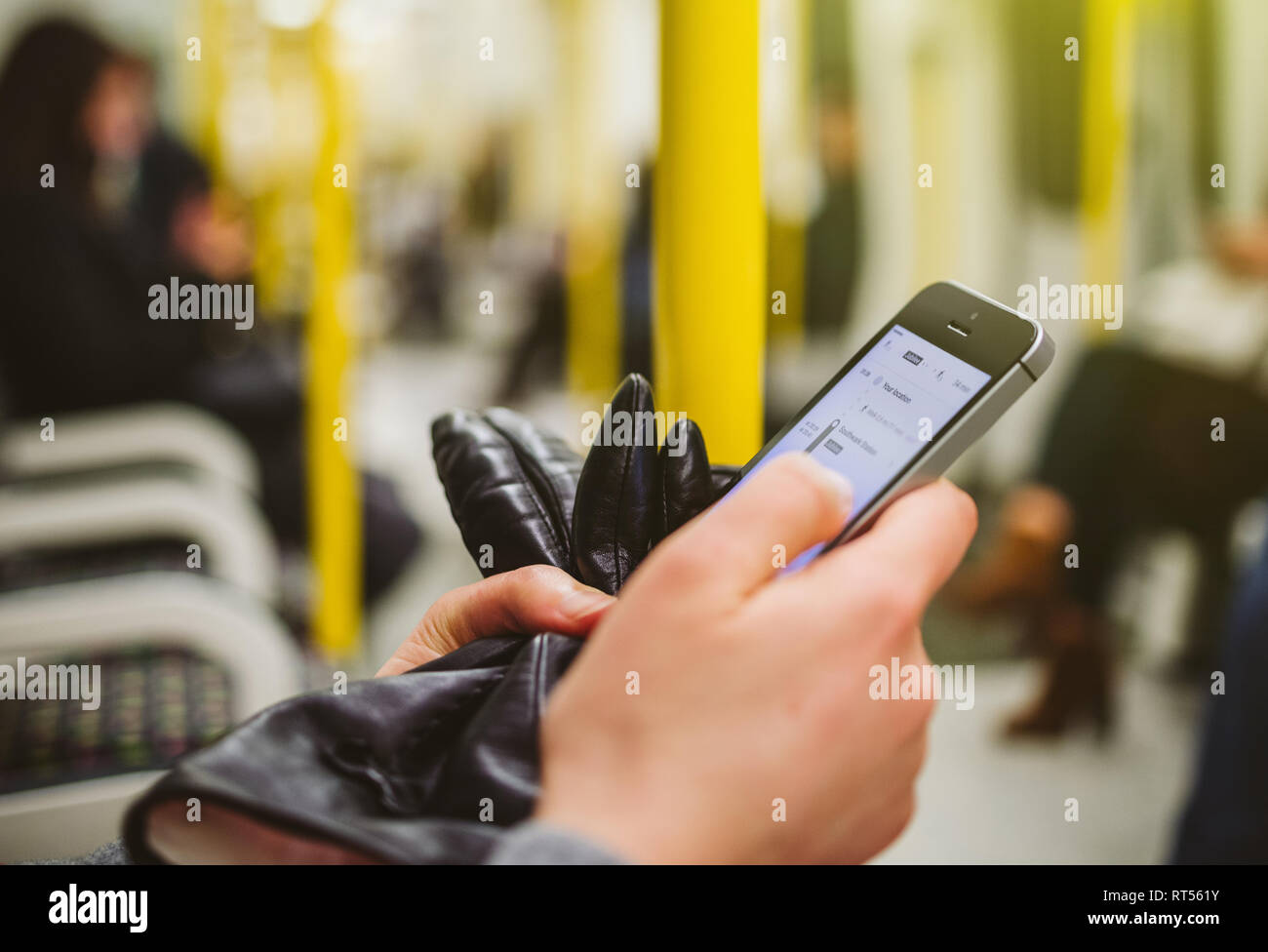 Frau mit Smartphone Telefon innerhalb der U-Bahn Station U-Karte mit Navigation Anmelden auf dem Bildschirm geöffnet und für den nächsten Zielort suchen - Wagen Innenraum Stockfoto