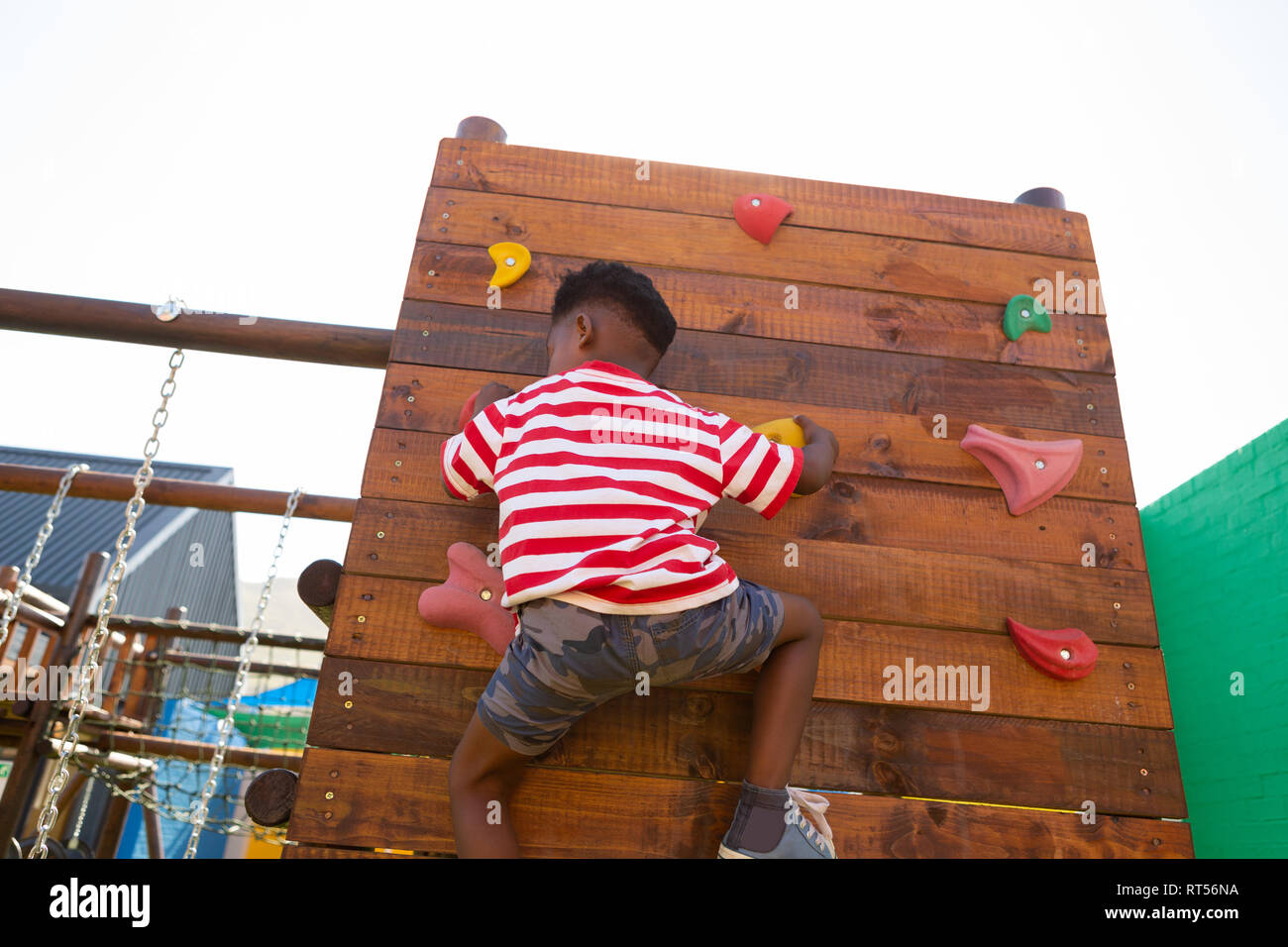 Schüler Klettern an einer Wand in der Schule Spielplatz Stockfoto