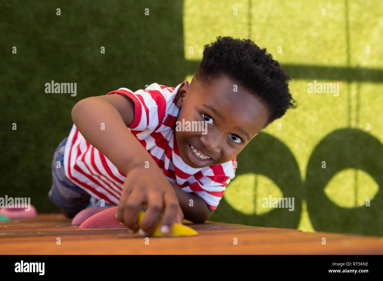 Schüler Klettern an einer Wand in der Schule Spielplatz Stockfoto