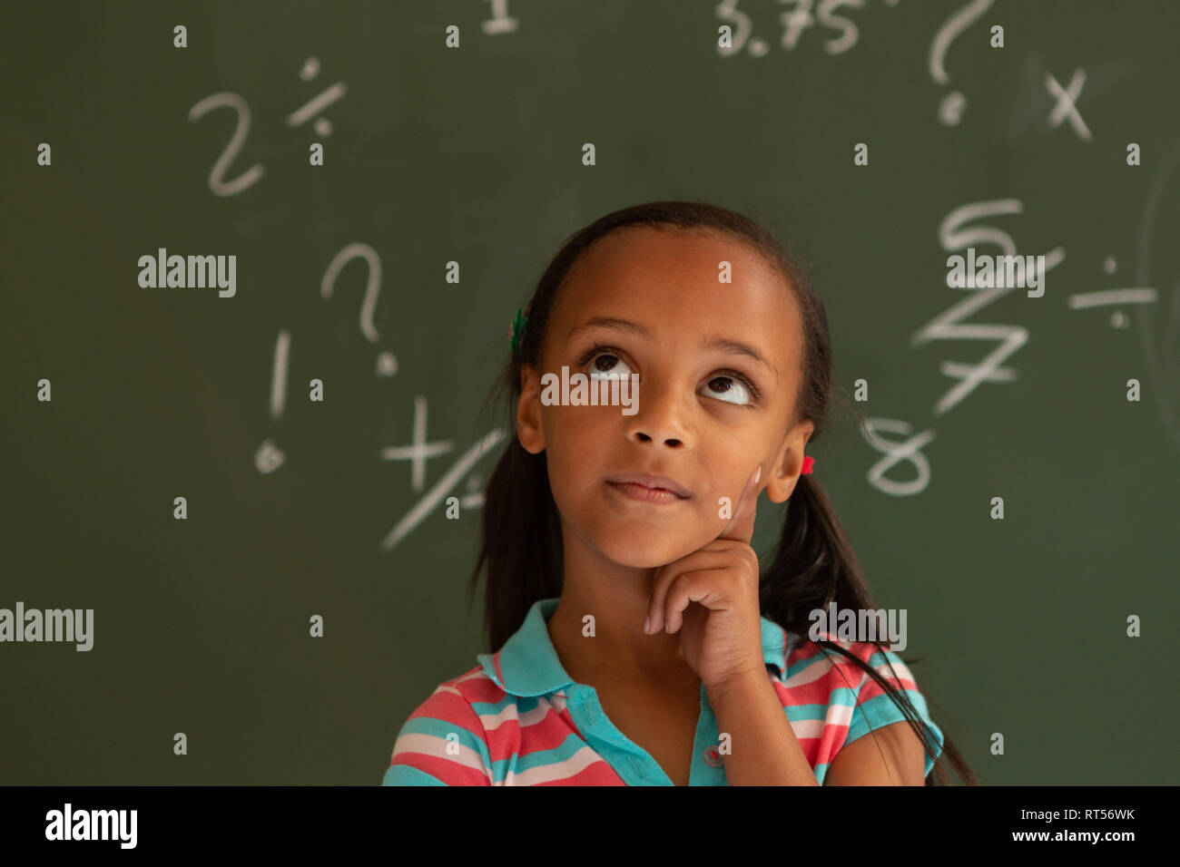 Die Schülerin gegen grüne Board in einem Klassenzimmer in der Schule Stockfoto