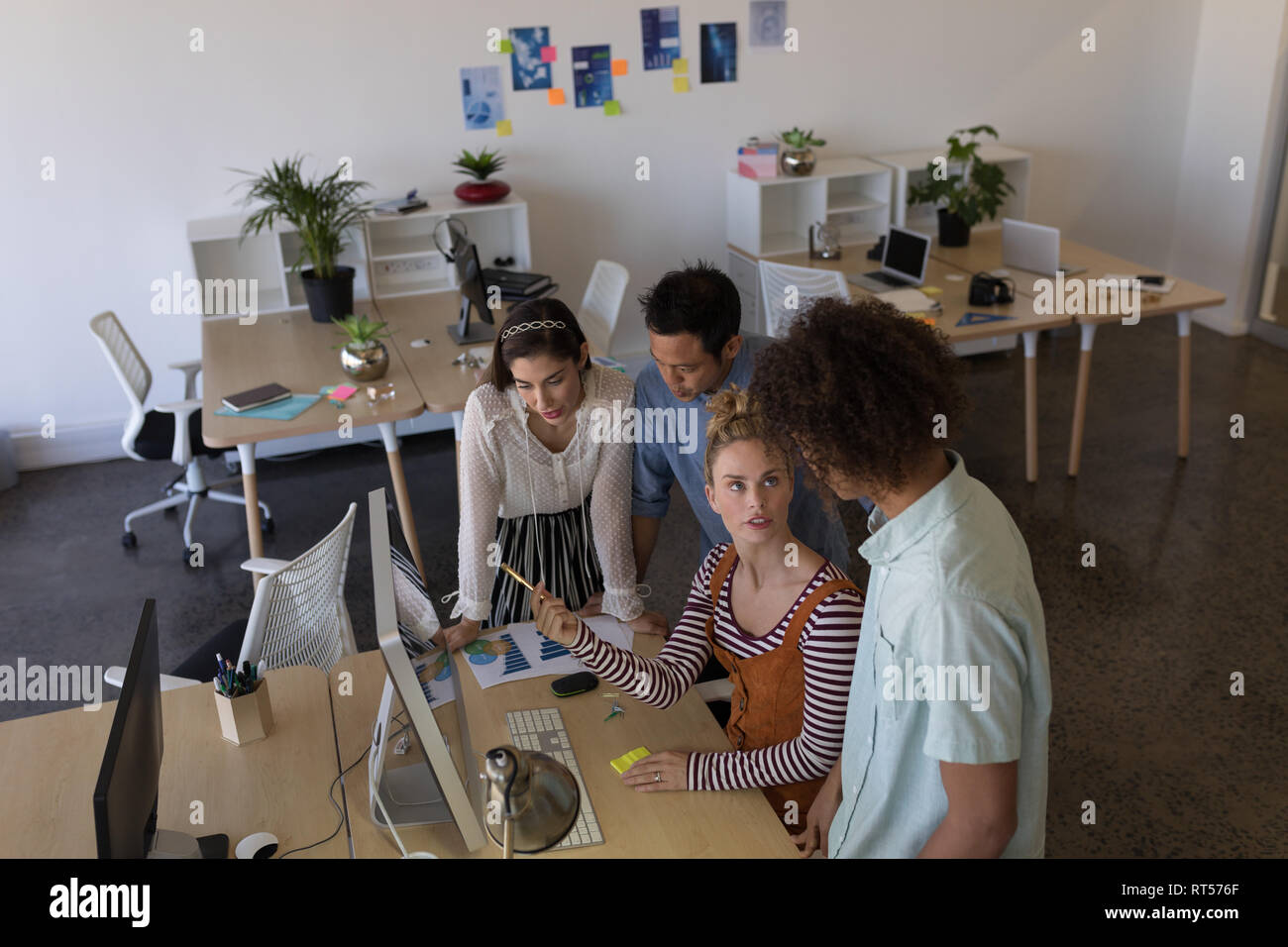 Kollegen diskutieren über Desktop-PC im Büro Stockfoto