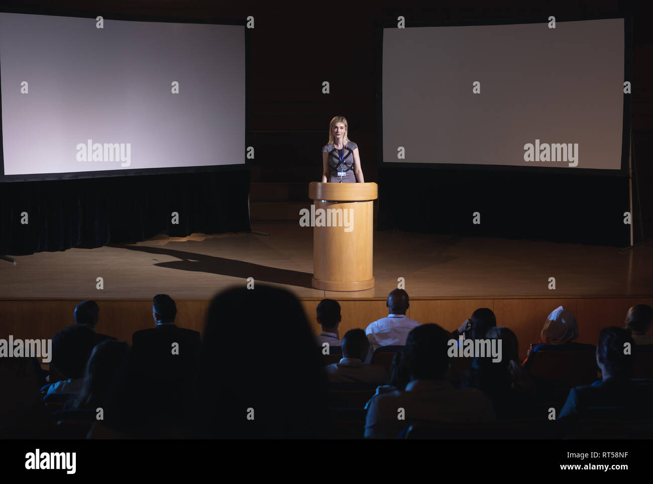 Geschäftsfrau, die herumstehen und Podium und die Präsentation für das Publikum Stockfoto