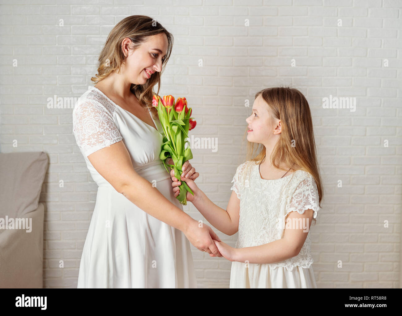 Tochter und motherin weiße Kleidung, die einander mit der Liebe. Familienkonzept Stockfoto