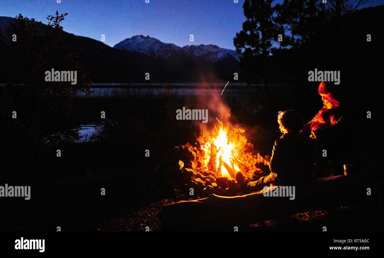 Argentinien, Patagonien, Lago Futalaufquen, Mutter mit Kindern am Lagerfeuer bei Nacht Stockfoto