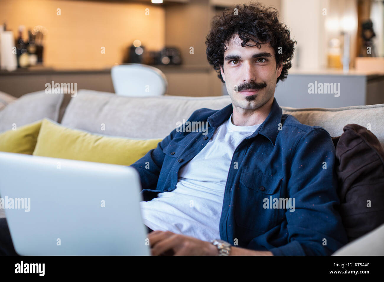 Portrait zuversichtlich Mann mit Laptop auf dem Sofa im Wohnzimmer Stockfoto