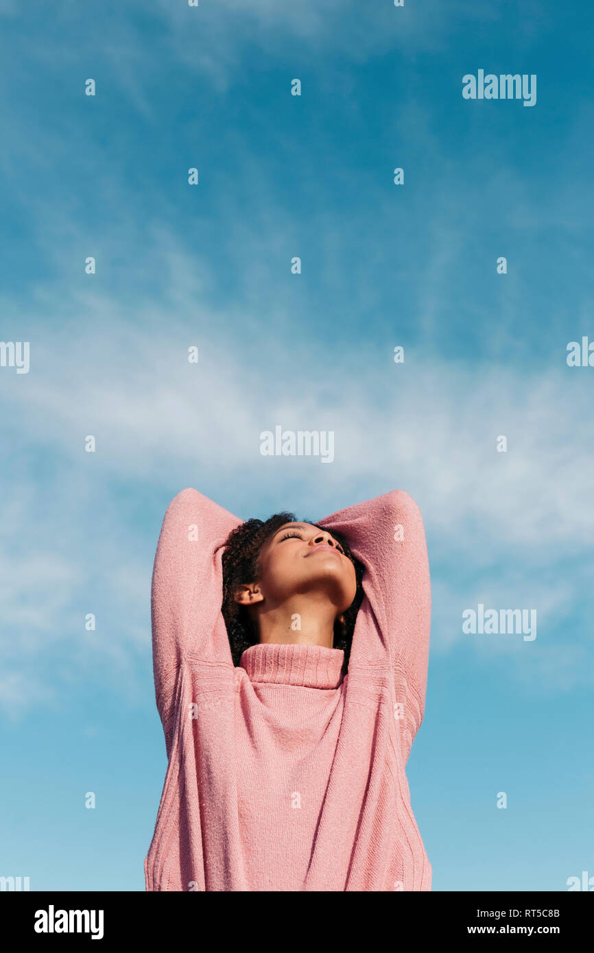 Entspannt junge Frau tragen rosa rollkragen pullover genießen die frische Luft Stockfoto