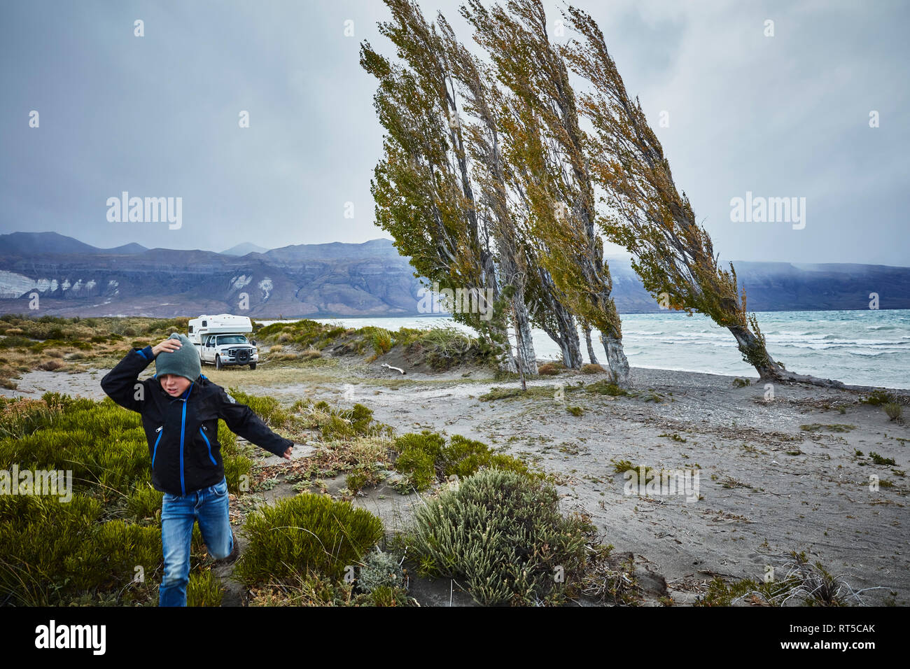 Argentinien, Lago Posadas, Junge läuft am See bei Sturm Stockfoto