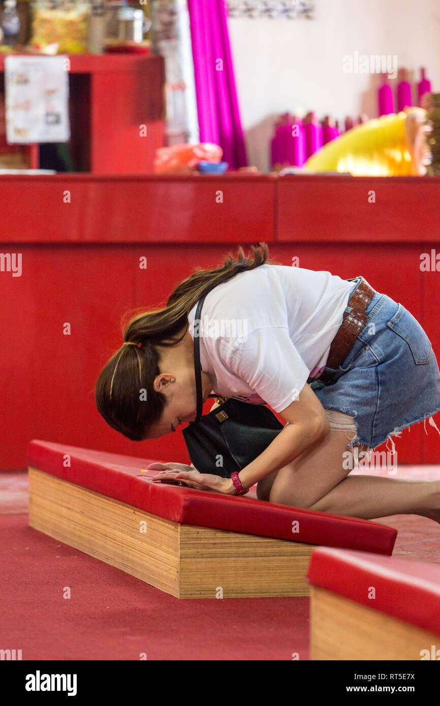 George Town, Penang, Malaysia. Frau in Shorts betend im Tempel der Göttin der Gnade, Kuan Yin Teng, Kong Hock Keong. Stockfoto