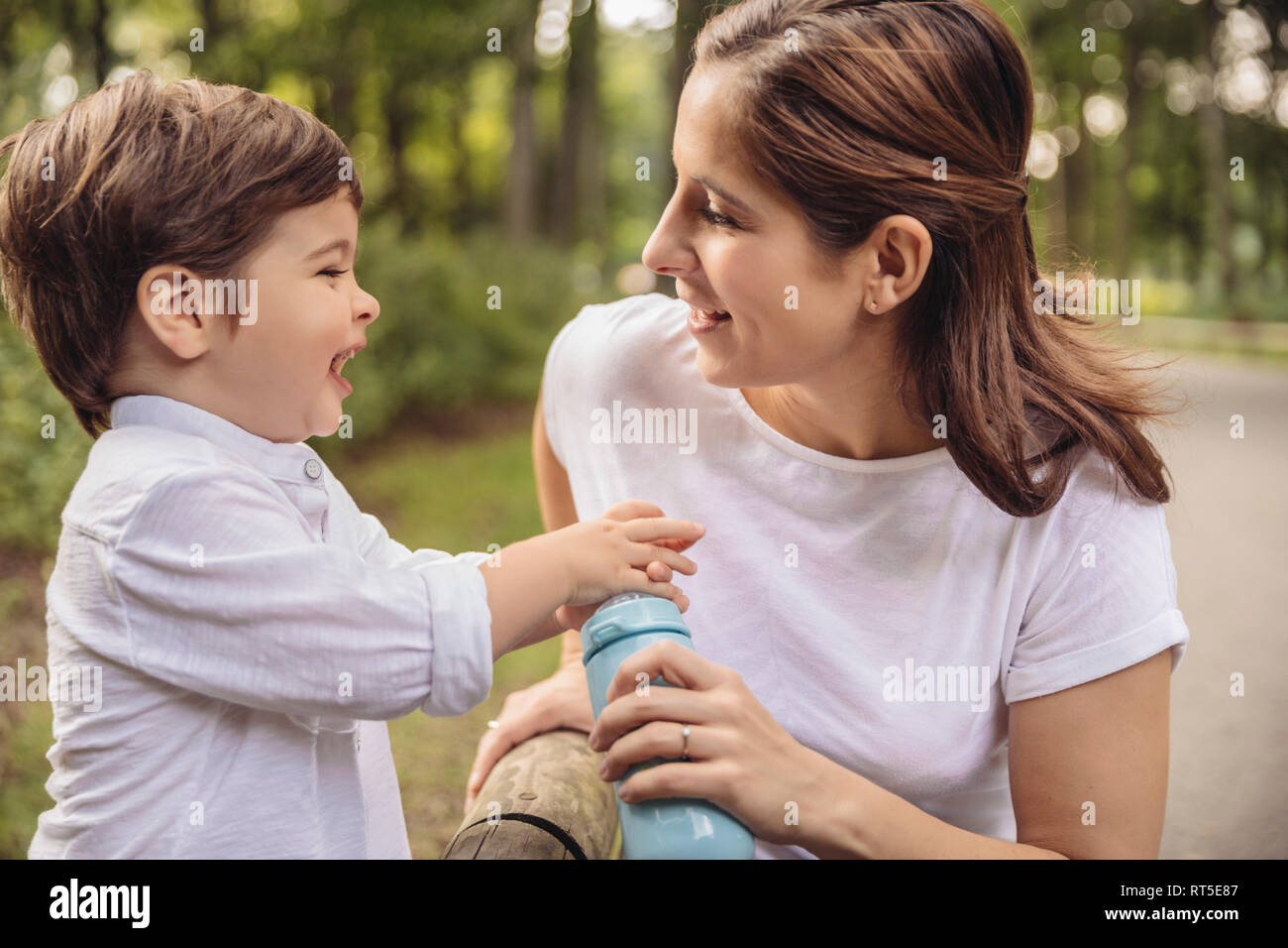 Mutter und ihren kleinen Sohn gemeinsam Spaß haben in einem Park Stockfoto