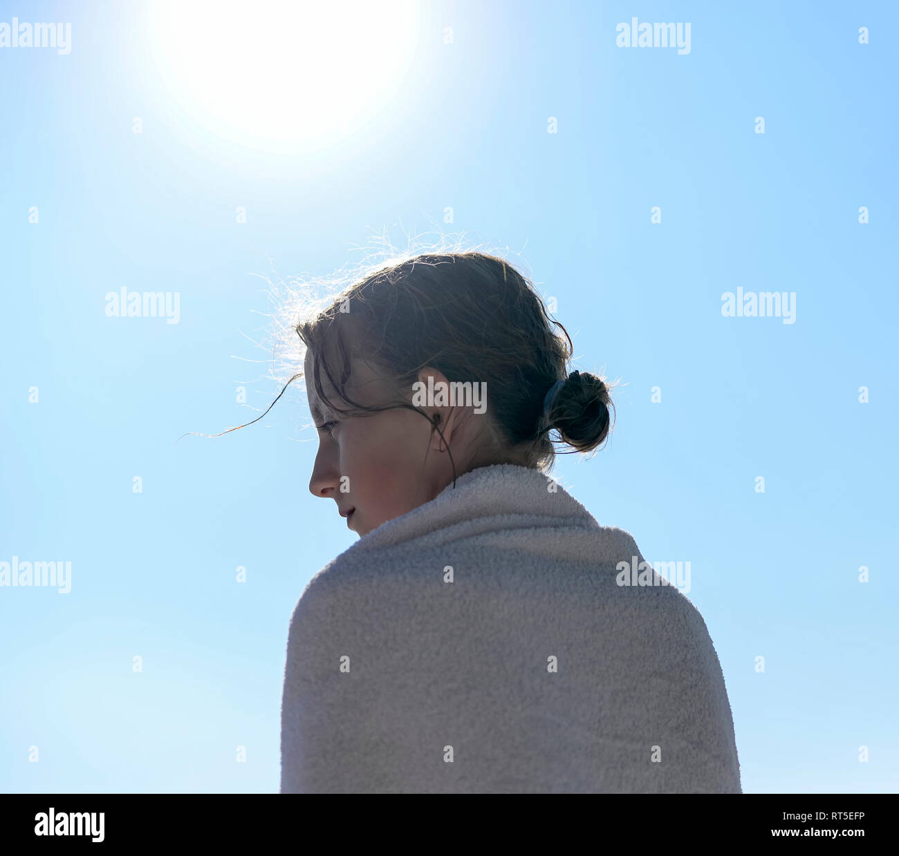 Profil von Mädchen an der Hintergrundbeleuchtung in ein Handtuch gewickelt Stockfoto