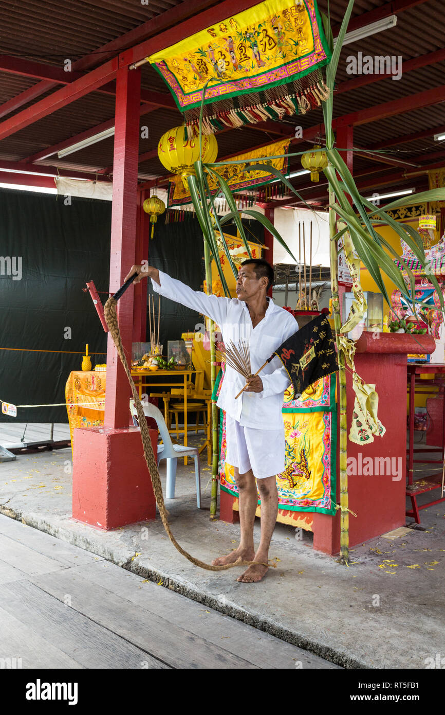 George Town, Penang, Malaysia. Priester führt Ritual aufschnappen Seil am Heiligtum vor Kang Thean Kong (Tempel des Gottes Segen), Kauen Jetty. Stockfoto