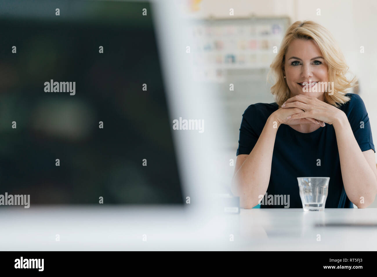 Portrait von lächelnden Geschäftsfrau am Tisch sitzen Stockfoto