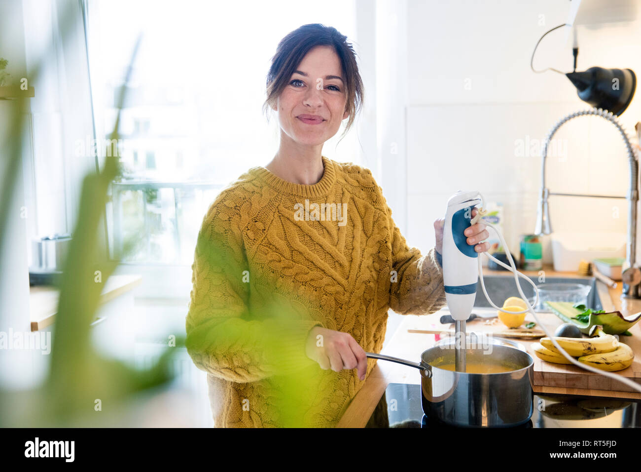 Frau Vorbereitung pumkin Suppe in Ihrer Küche Stockfoto