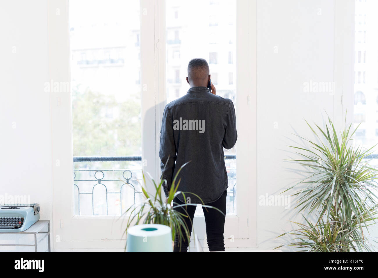 Rückansicht der Geschäftsmann am Telefon im Büro Blick aus Fenster Stockfoto