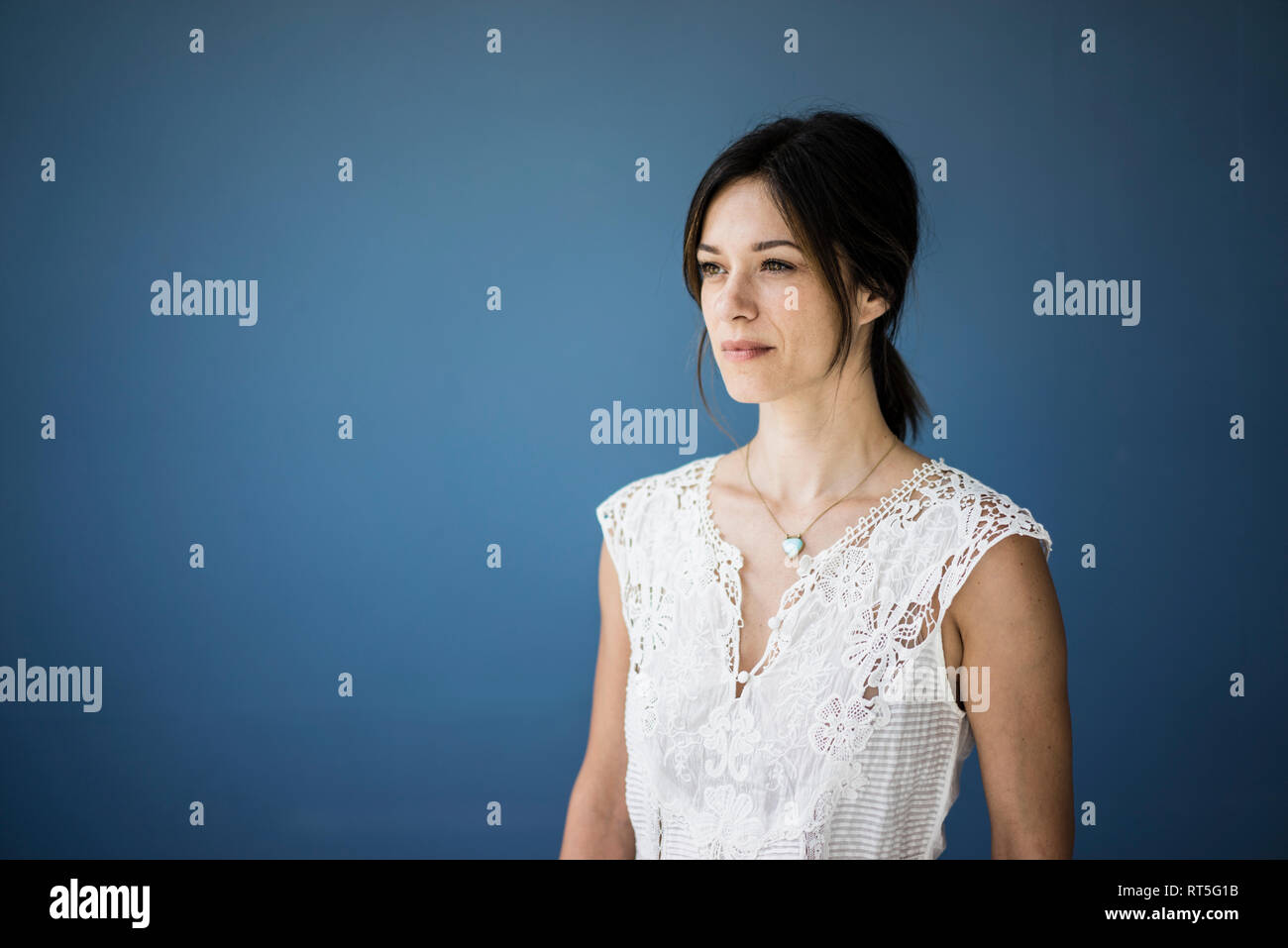 Porträt einer schönen Frau vor blauem Hintergrund Stockfoto