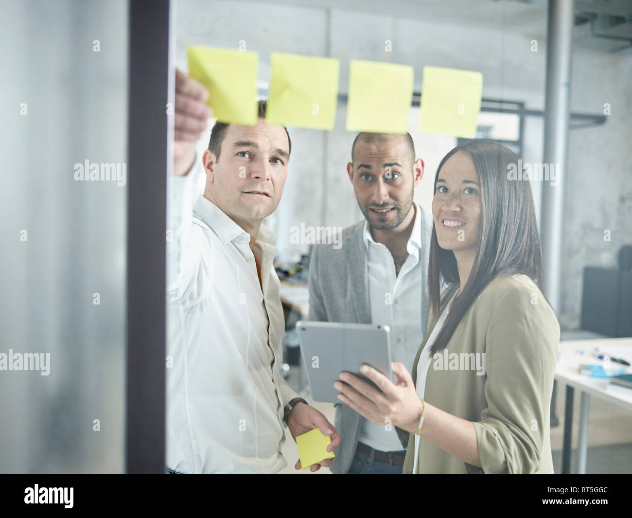 Kollege mit Haftnotizen und Tablette im Büro Stockfoto