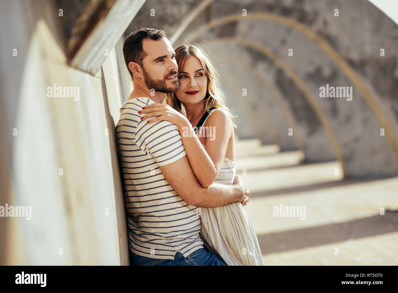 Spanien, Andalusien, Malaga, zärtlich touristische Paar umarmen Unter einem Torbogen in der Stadt Stockfoto