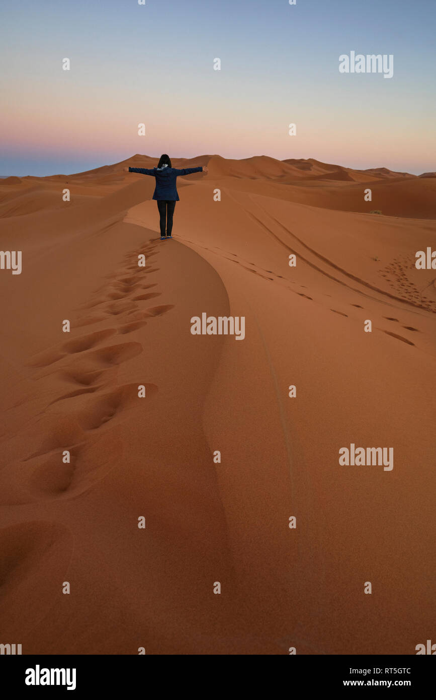 Marokko, Rückansicht der Frau auf Wüste Düne in der Dämmerung Stockfoto